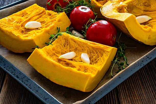 istock Uncooked pumpkin with thyme and garlic on baking paper 2234793217