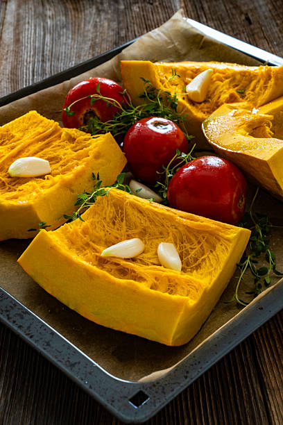 istock Uncooked pumpkin with thyme and garlic on baking paper 2234793252