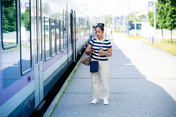 istock Confident Asian woman on train platform using smartphone, symbolizing modern city lifestyle, mobility, technology, commuting, and connectivity. 2234796248