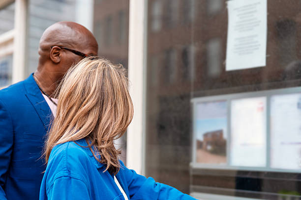 Couple reading information on a display board in an urban setting during a sunny day in the city