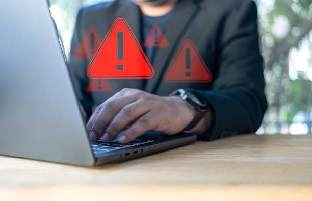 istock Businessman using laptop with spam virus with warning to alert internet security and data breach or hacker or spyware. 2234799134