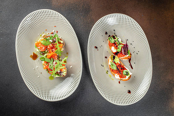 istock Two plates with assorted bruschetta topped with fresh vegetables, herbs, and cheese 2234800973