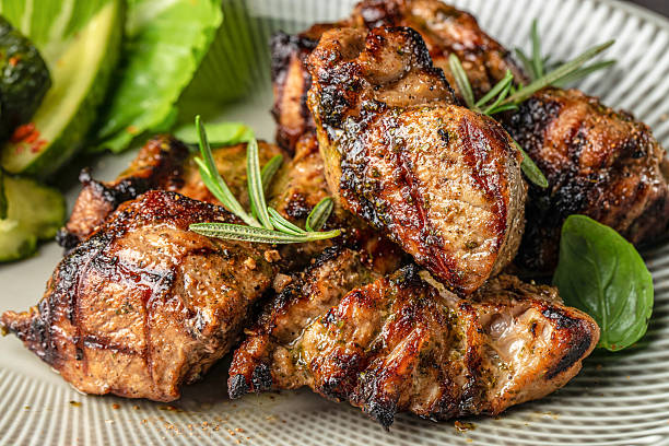 istock Grilled meat pieces with herbs and fresh vegetables on a plate 2234800980