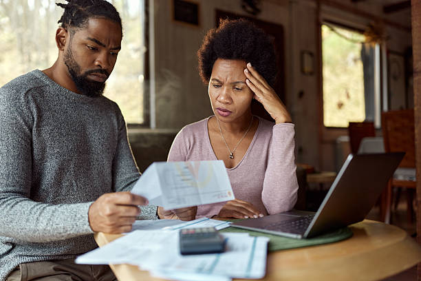 istock Worried black couple having problems with their financial bills at home. 2234801197