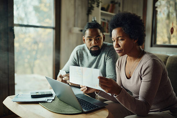 istock Black couple paying their bills over a computer at home. 2234801456