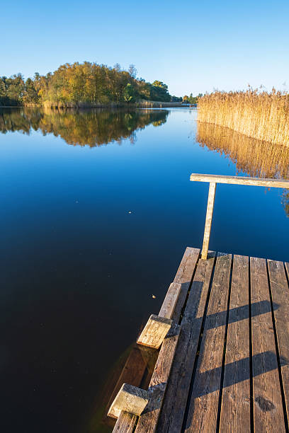 istock Bathing jetty by a calm lake in autumn 2234802252