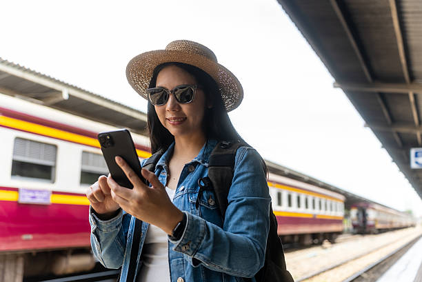 istock Young asian traveler backpacker woman using smartphone looking map and checking train schedule and browsing social media online at train station, solo travel female lifestyle and internet technology. 2234802541