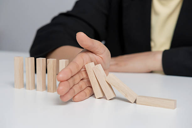 istock Hand stopping or preventing a falling block. Concept of hedging, risk elimination. 2234803615
