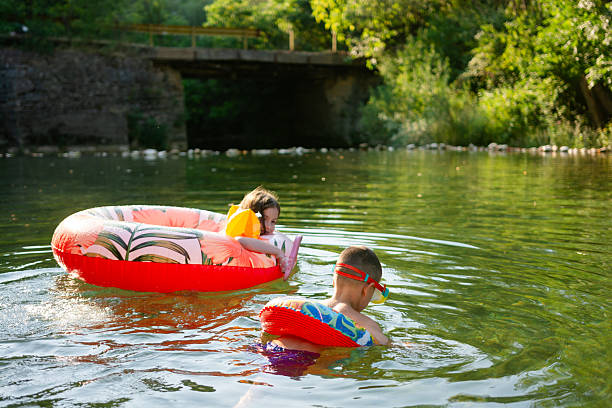 istock Children swimming with inflatable rings in river under bridge 2234803842