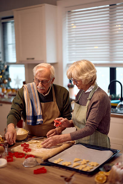 istock Senior couple using Christmas molds while making cookies in the kitchen. 2234805634