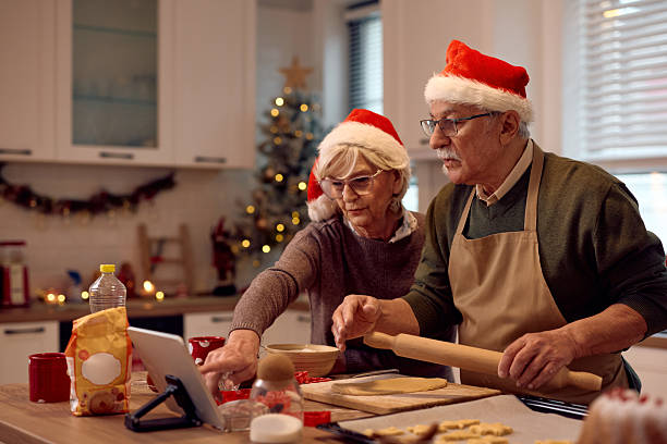 istock Senior couple using touchpad while making Christmas cookies in the kitchen. 2234805693