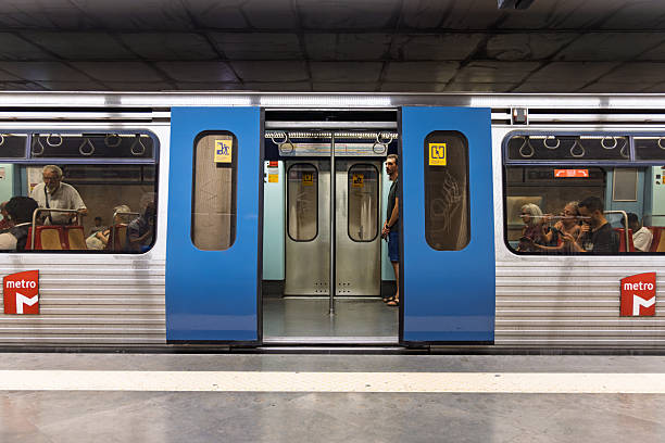 A view of a metro train stopped at a station with its doors open. The focus is on the open doorway, showing the interior of the train and the platform. Lisbon, Portugal. 1 August 2025.