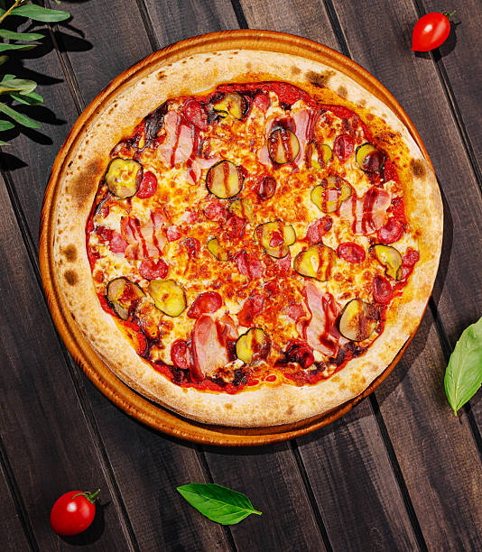 istock Delicious pizza topped with meats and pickles on a rustic wooden table 2234810030
