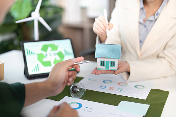 istock ESG Focus. Business professionals analyzing sustainable housing solutions with models. 2234810294