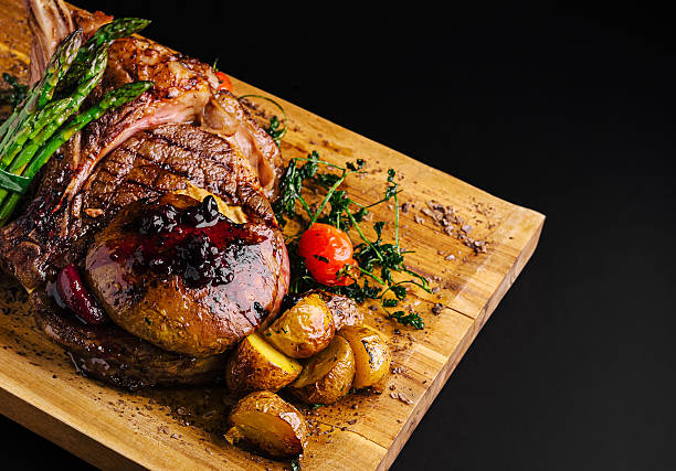 istock Delicious grilled steak with vegetables presented on a wooden platter 2234810295