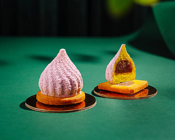 istock Two exquisite pastries sit elegantly on gold bases against a deep green surface 2234810370