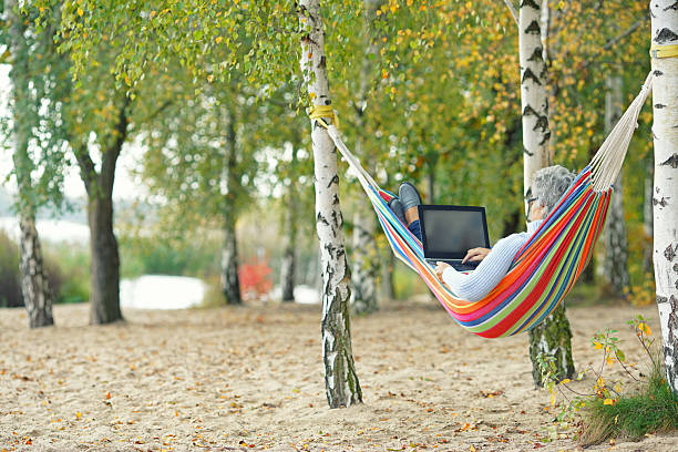 istock Serene Autumn Day: Senior Enjoying a Laptop by the Lake 2234810420