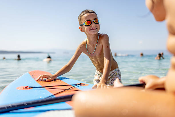 istock Boy Enjoying Paddleboarding on a Sunny Summer Day at the Beach 2234810681