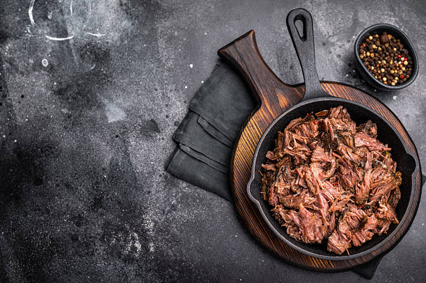 istock Traditional barbecue pulled beef, Slow cooked meat cooked in a smoker. black background. top view 2234810823