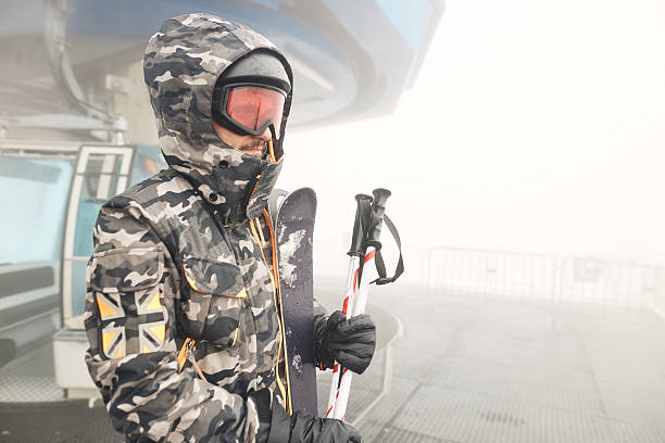 Man enjoying skiing on winter day. Chairlift behind him.