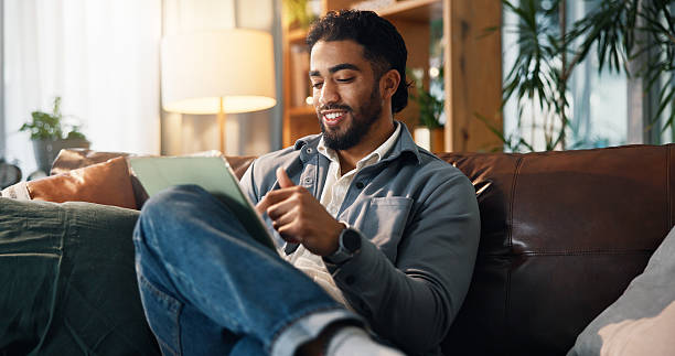 istock Remote work, man and happy with tablet on sofa for small business development, research or planning. Freelance entrepreneur, person and smile with digital app in home for startup proposal and review 2234814793