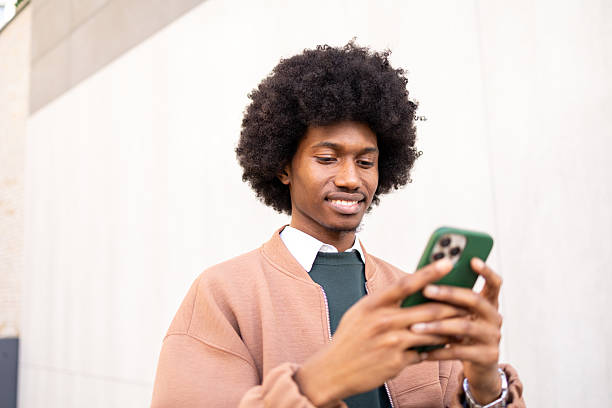 istock Smiling young man using smartphone outdoors in casual and stylish clothing 2234817619