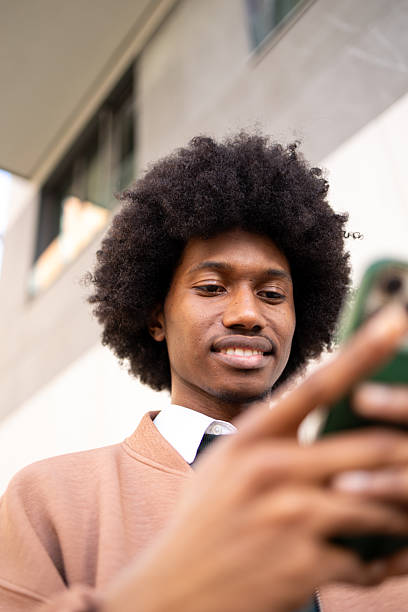 istock Smiling young man using smartphone outdoors in casual and stylish clothing 2234817620