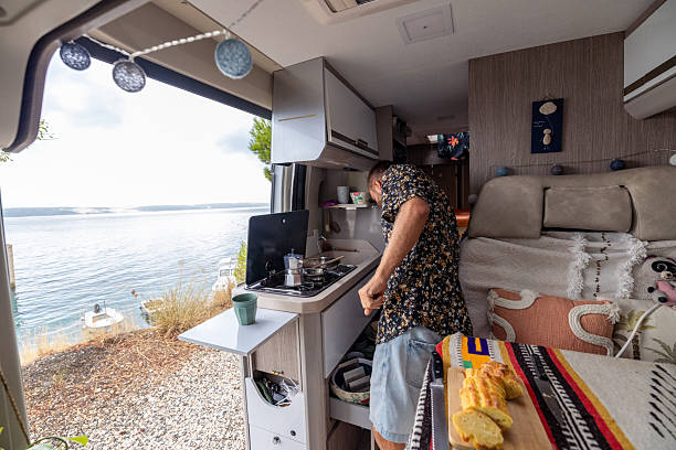 istock Man Preparing Food Inside Camper Van Near Water 2234817627