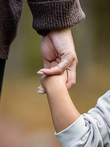 Mother and son holding hands.