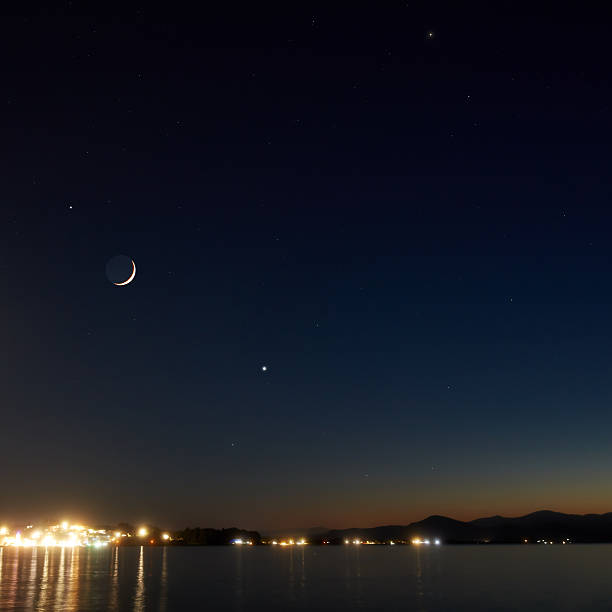 istock Young crescent Moon with stars and planets over ocean sea waters. 2234817953