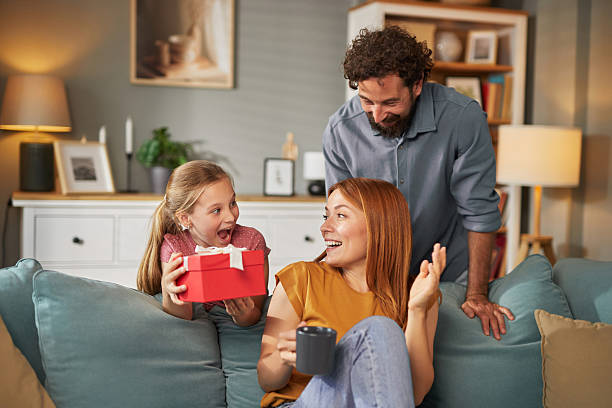 istock Daughter surprising her mother with a gift at home 2234818833