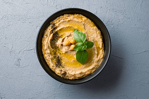 A traditional dish or appetizer hummus or baba ghanoush on vintage background