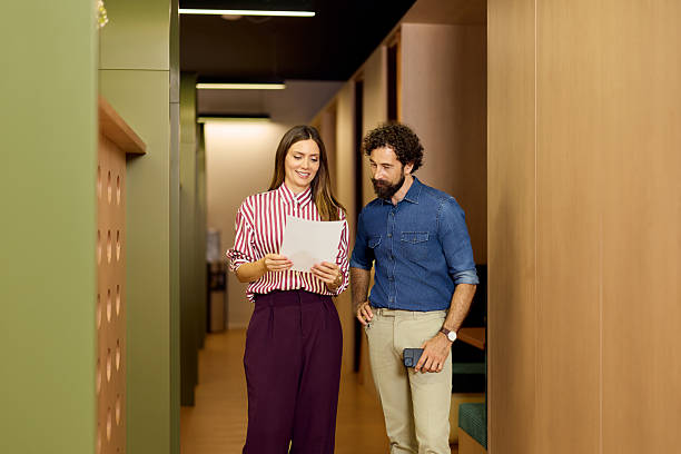 istock Two Professionals Review Document in Modern Office Hallway with Positive Atmosphere 2234821690