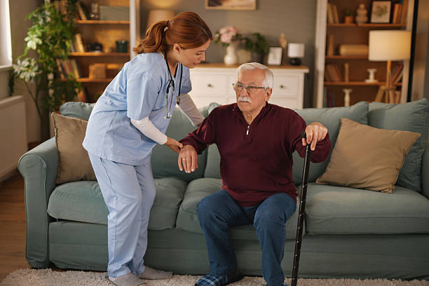 istock Nurse helping senior man getting up from sofa at home 2234822081