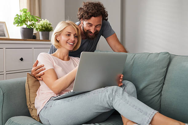istock Couple enjoying quality time together while using a laptop on a cozy couch in a 2234823388