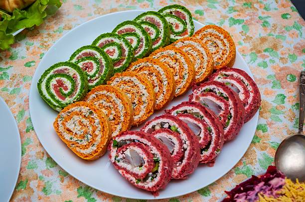 A visually appealing arrangement of colorful sliced appetizer rolls, perfect for a gathering or meal. A visually appealing arrangement of colorful sliced appetizer rolls, perfect for a gathering or meal.