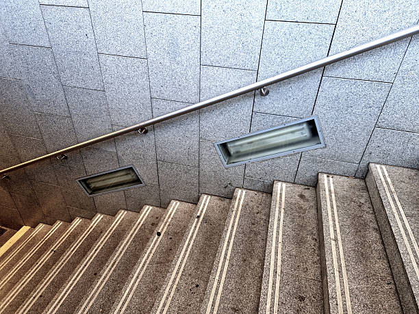 stone tile cladding and staircase lighting with side lights. stainless steel handrail on the stairs. anti-slip strips