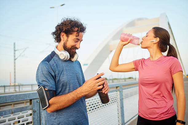 istock Runners drinking water after training outdoors 2234828171