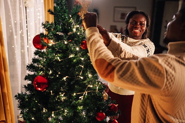 istock Couple decorating christmas tree together at home 2234829385