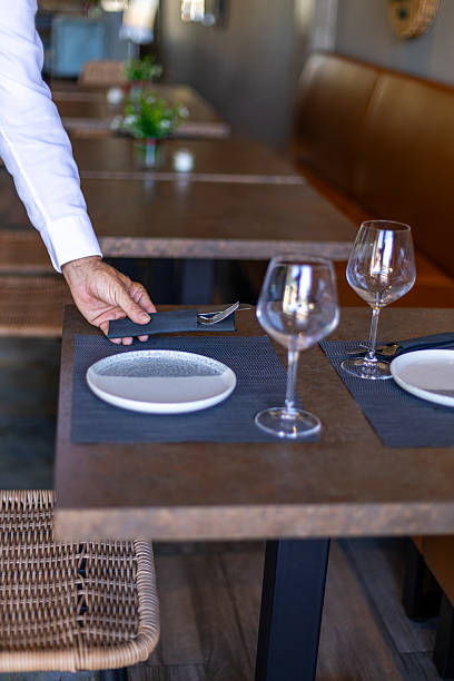 istock Waiter placing cutlery on table in elegant restaurant 2234829728