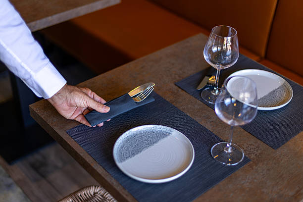 istock Waiter placing cutlery on restaurant table for dinner service 2234829744