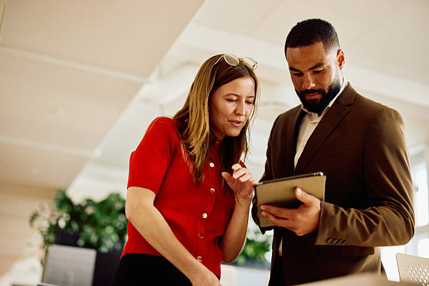 istock Two focused entrepreneurs having a discussion and reviewing work on a digital tablet in an office 2234830484