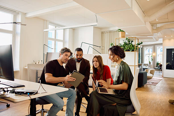 istock Multiethnic business team collaborating with laptops and notes in a bright office with a modern design 2234830525