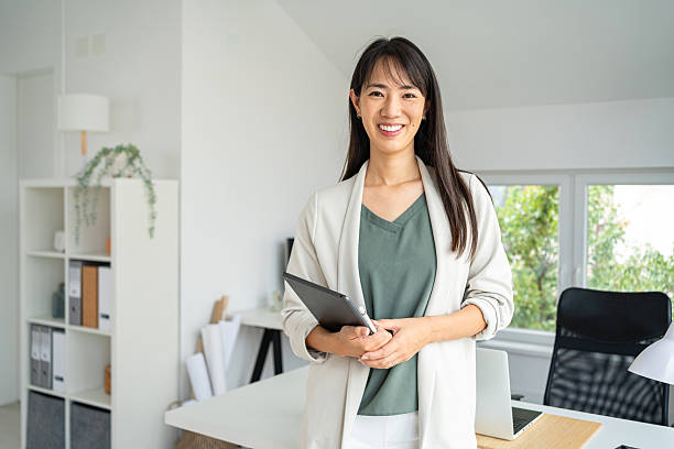 istock Smiling Professional Woman Holding a Tablet in a Bright Office 2234831802