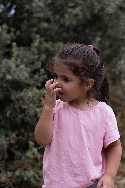istock Curious child exploring nature and touching nose outdoors 2234835739