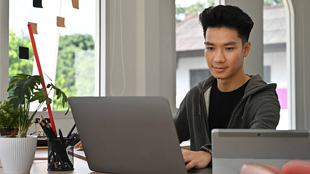 istock A Focused Asian Creative freelancer man works on a laptop, developing graphic content from an office workspace 2234836129
