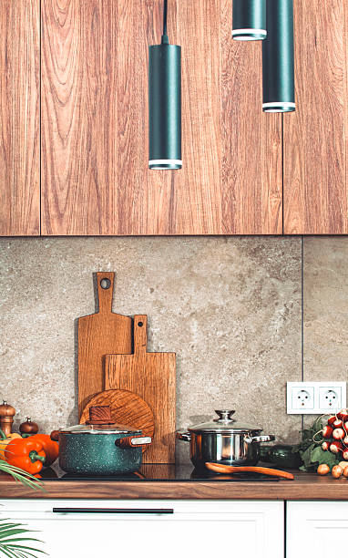 istock Kitchen countertop with utensils, pans on induction hob, bowls, cutting boards, vegetables 2234839871