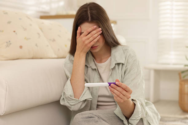 istock Upset woman with negative pregnancy test at home 2234840816