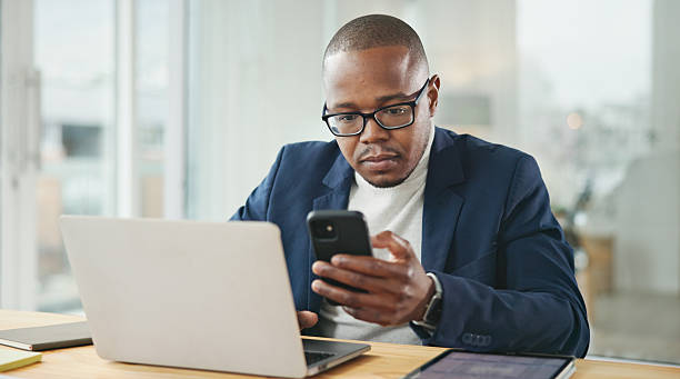istock Professional Businessman Using Smartphone at Office Desk with Laptop 2234841212