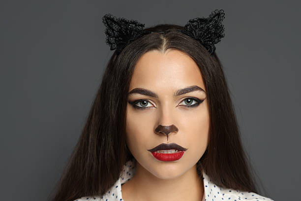 istock Attractive woman with cat makeup and ears on grey background 2234841514